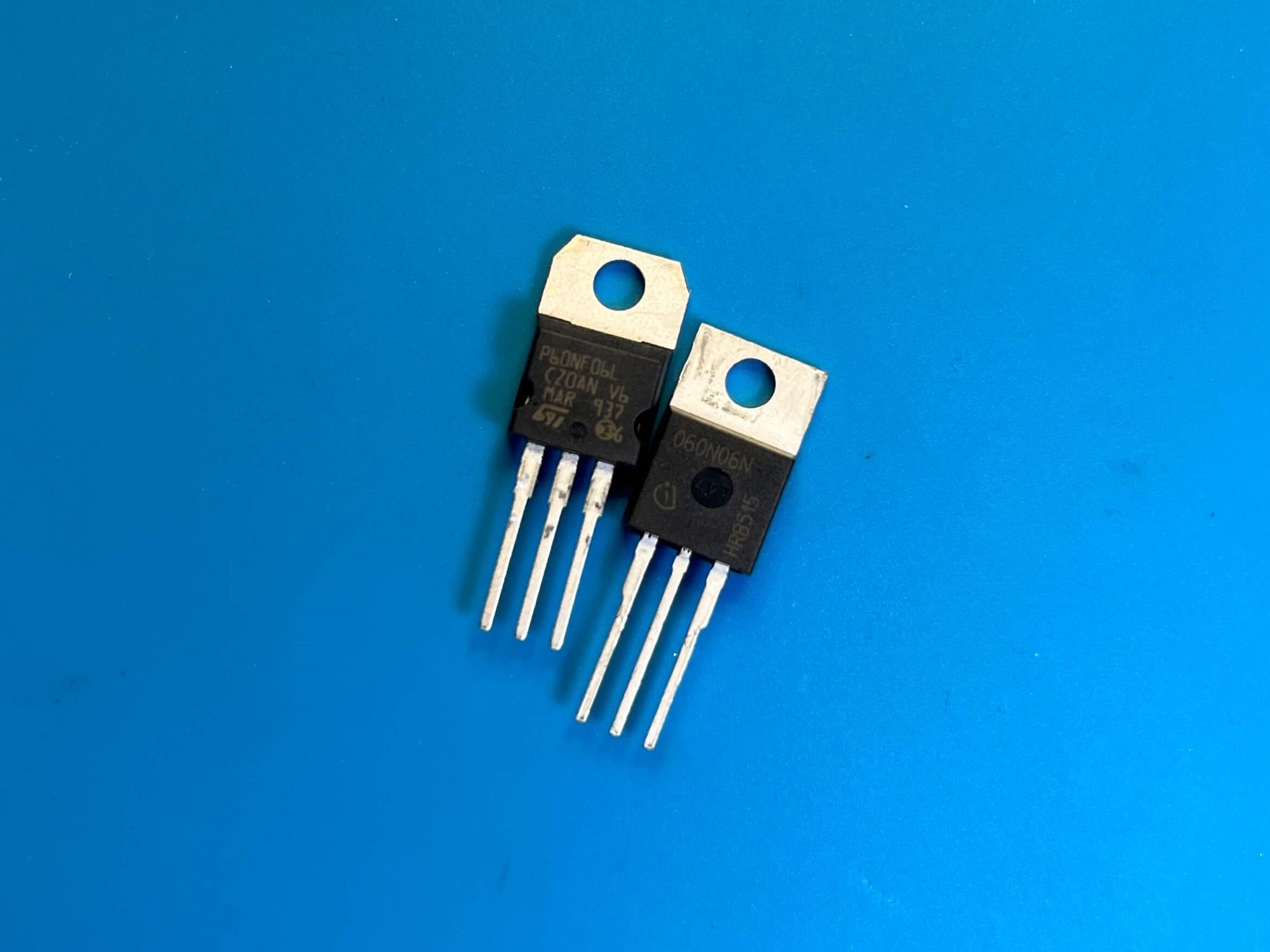 Photo of two logic-level MOSFETs on a blue electronics mat.