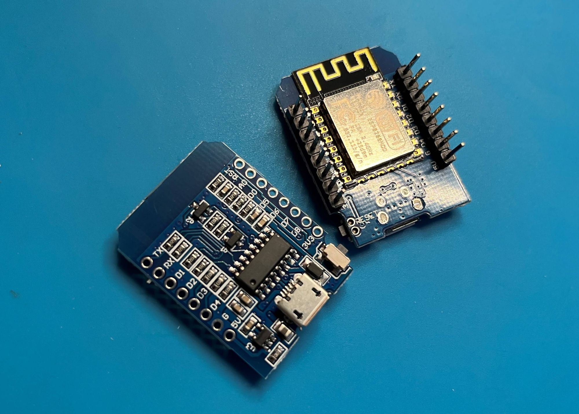 Picture of two Wemos D1 mini boards on a blue electronics silicon mat