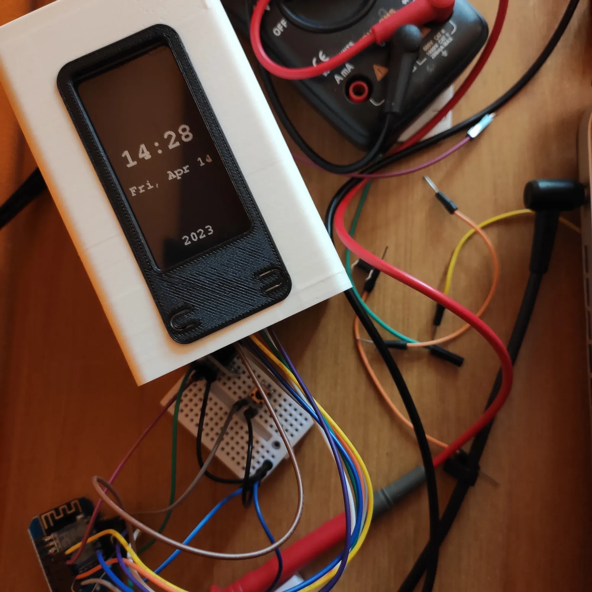 Photo of a prototype of digital clock made of an ePaper display on a 3D printed enclosure